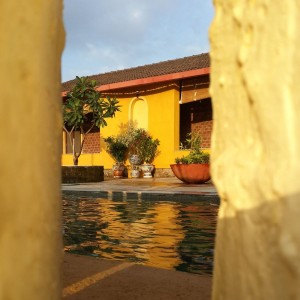 Courtyard and swimming tank seen through a brick jali